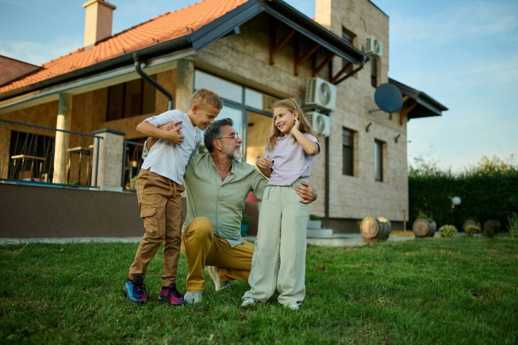 A family standing on the lush green lawn of a classic red-brick Chicago multi-family two-flat building, representing home equity and real estate investment.