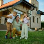 A family standing on the lush green lawn of a classic red-brick Chicago multi-family two-flat building, representing home equity and real estate investment.